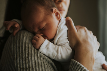 mother holding her baby indoors