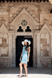 Fototapeta Na drzwi - Brunette girl in blue summer dress walking on old narrow street