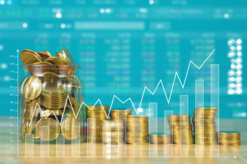 Double exposure of coin stack with stock market screen chart board and candle stick for financial business and investor analysis concept idea.