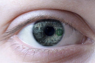 Human eye with a one hundred dollar bill with Benjamin Franklin portrait reflection