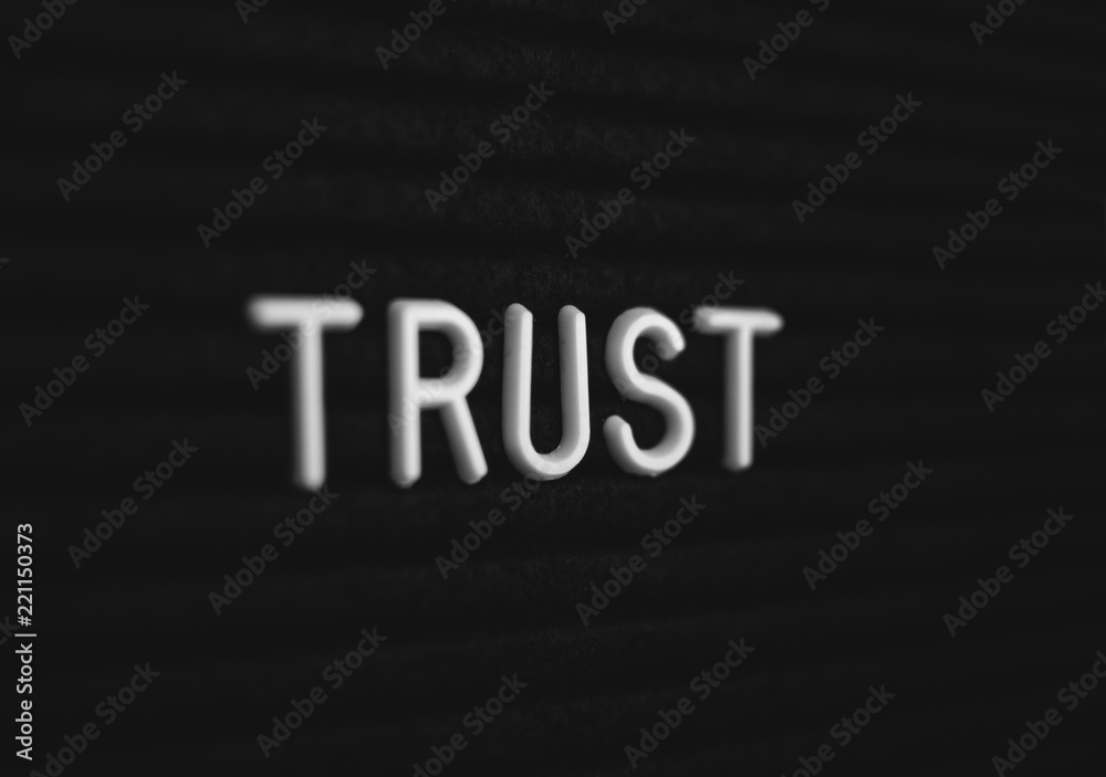Word trust written on the letter board. White letters on the black