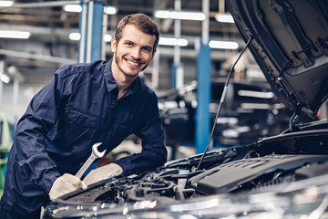 Auto car repair service center. Mechanic examining car engine