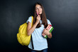 © 5second - Young girl with backpack and books on blackboard background