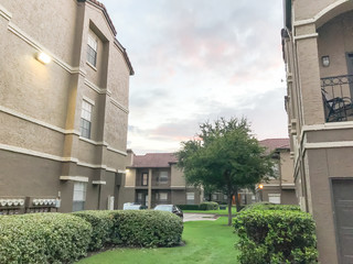 Canvas Print - Typical apartment complex condos with attached garage and uncovered parking lots at suburban area in Irving, Texas, USA.