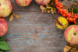 Fototapeta Kuchnia - Autumn background from fallen leaves and fruits with vintage place setting on old wooden table. Thanksgiving day concept