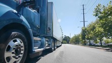 Semi Truck Driving Down Street In Summer