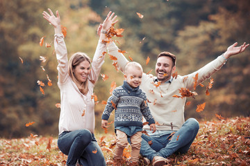 Happy family having fun in autumn forest