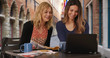 © Mark Adams - Lovely blonde woman with girlfriend using laptop at cafe in Bruges, Belgium