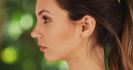 Wall Mural - Close-up profile of beautiful model posing on green and white background