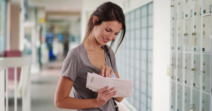 Wall Mural -  - White millennial female checking stack of letters while in post office hallway
