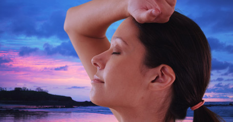 Wall Mural - Side view of carefree woman standing on beach enjoying ocean breeze