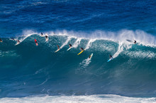 Surfers Riding A Wave In Hawaii