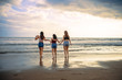 © TheVisualsYouNeed - young women friends or sisters playing together in the beach on sunset light having fun enjoying summer holidays trip in girlfriends love and friendship concept