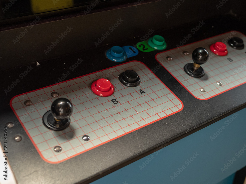 Joystick and button controls of classic arcade cabinet in dark arcade 