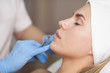 The cosmetologist makes injections of botulinum toxin in the lips of the patient. Cosmetology skin care.