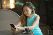 © lashkhidzetim - Beautiful Asian lady talking on the phone in cafe.