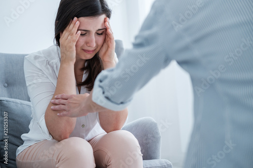 Fotografía Young woman suffering from depression crying in her therapist's office