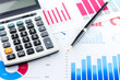 © zodar - Calculator and Pen on Business Graphs finance document.