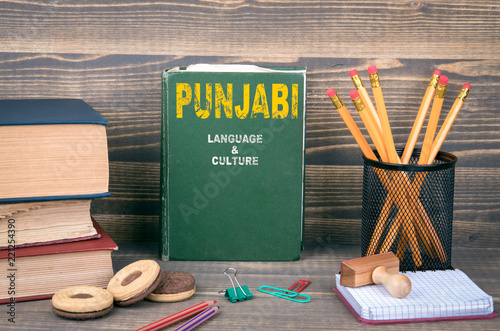 Fotografia, Obraz Punjabi language and culture concept. Book on a wooden background