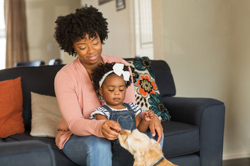 Little girl and her mom playing with thier dog.