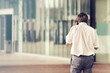 © missizio01 - walking businessman with copy space, busy male using smartphone on city building background
