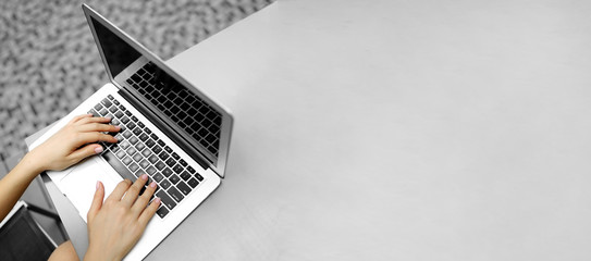 website heading and banner of laptop with female typing hands, copy space in grey color. concept of 