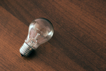 Bulb on wooden table, concept of idea