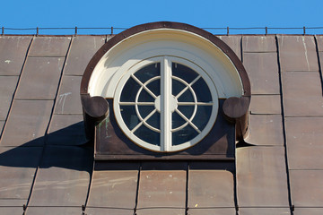 Wall Mural - Round attic window in a metal covered roof