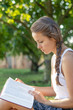© PhotoGranary - Christian worship and praise. A young woman is reading the bible in the early morning with sun in the background.
