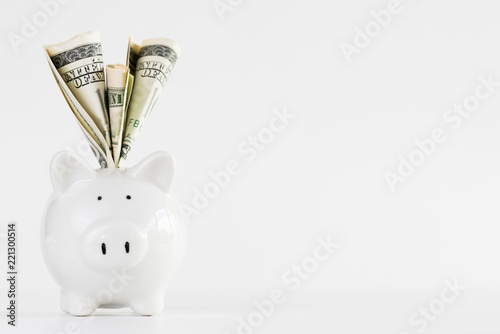 Fotomural America dollars banknotes money into piggy bank on white background