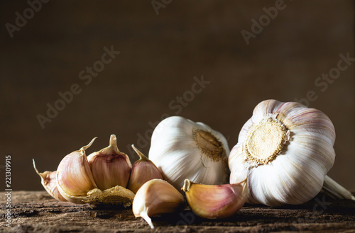 Cuadros en Lienzo Closeup garlic on wooden texture on for cooking on dark background