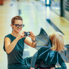 Wall Mural - mother and daughter taking photo with digital camera