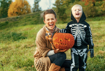 Wall Mural - mother and child showing Halloween pumpkin Jack O’Lantern