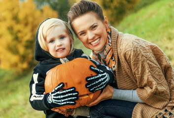 Wall Mural - mother and daughter with carved Halloween pumpkin