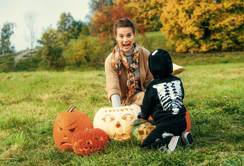 Wall Mural - mother and daughter playing with Halloween pumpkins Jack O’Lantern