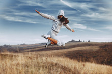 Happy Young Woman Jump In The Air In Nature