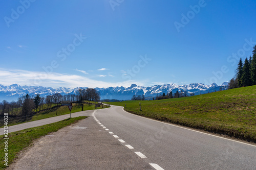 Fotografie, Obraz Sunny Miday on road looking towards Alps