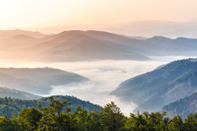Gorgeous Morning Scene In High Mountains. Fog Soar Over Mountain Villages. Panoramic Aspect Ration. Hiking Or Any Outdoors Activity Background. Suitable For Wallpapers On Screen Of Digital Device.