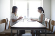 © Monet - 女性社員とマネージャーが会議室で話している