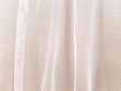 close up of blush colored sheer tulle fabric