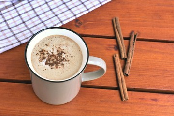 Wall Mural - Mug of hot chocolate with cinnamon, on a wooden table, autumn warming drink.