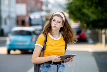 Young girl student with tablet and urban background