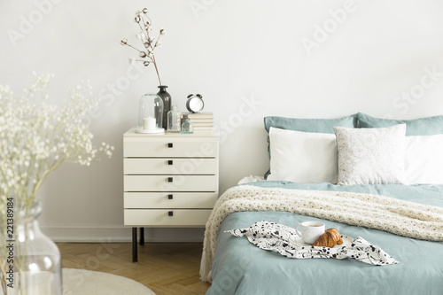 A Bright Bedroom Interior With Sage Green And White Bedding