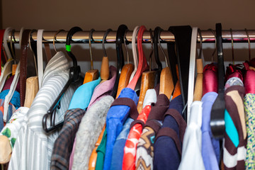 Hangers with different clothes in wardrobe in usual flat