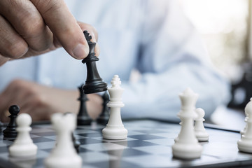 Wall Mural - Businessman's hand playing chess game to development analysis new strategy plan, business strategy leader and teamwork concept for win and success