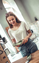 Wall Mural - Young woman chooses shoes in shop