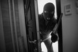 © luckybusiness - Burglar breaking in a house with crowbar