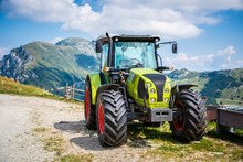 Green Tractor On Farm In Italian Alps