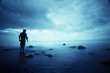 landscape sunset on the sea, man on the lake shore at sunset, beautiful place  nature, water and seashore, concept of waiting for loneliness