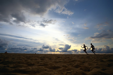 silhouettes of athletes running along the beach / sports summer in the warm sea, healthy rest, sports activity, summer vacation